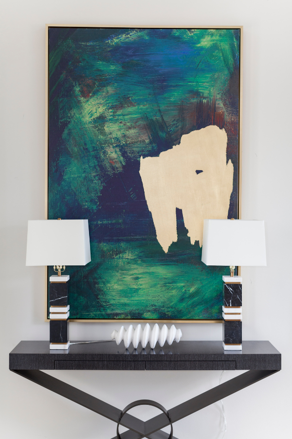 paintings above a table with lamp