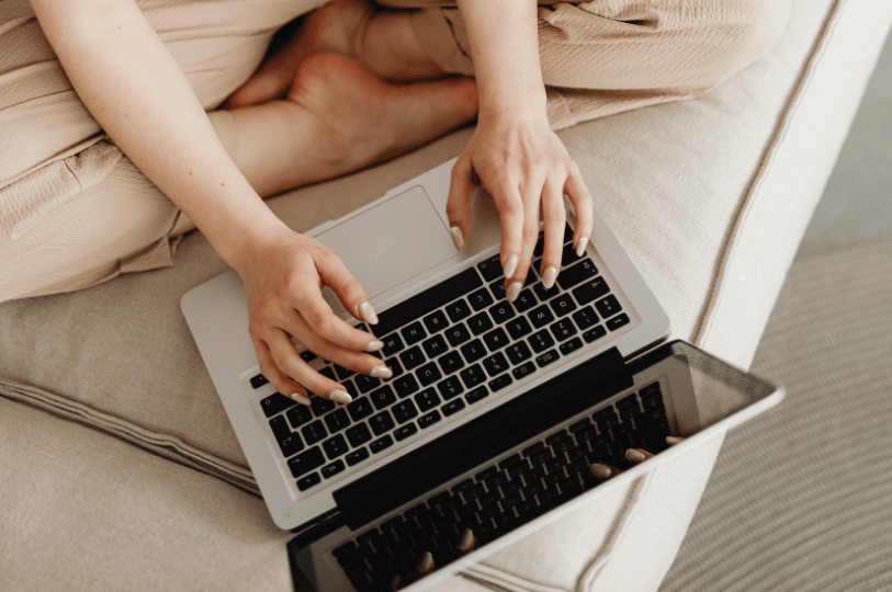 Close-up overhead shot of hands typing on a laptop keyboard, illustrating the process of optimizing a Google Business Profile for local SEO.