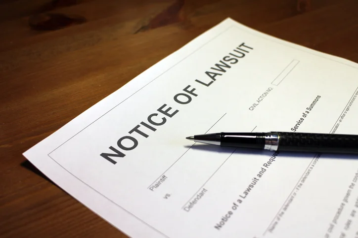 A pen over a notice of lawsuit form