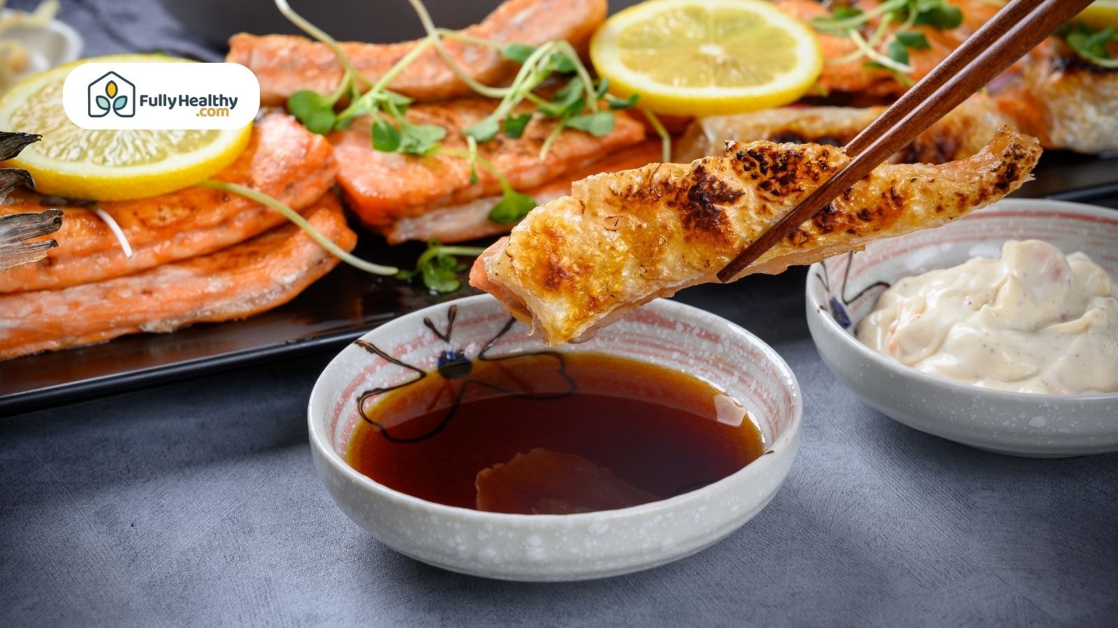 Grilled fish dipped in soy sauce with chopsticks