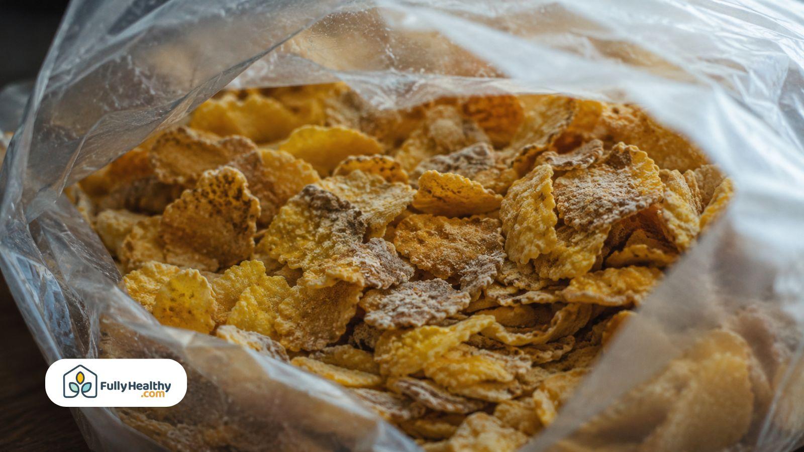 Close-up of corn flakes inside an opened cereal bag showing cereal texture and detail.