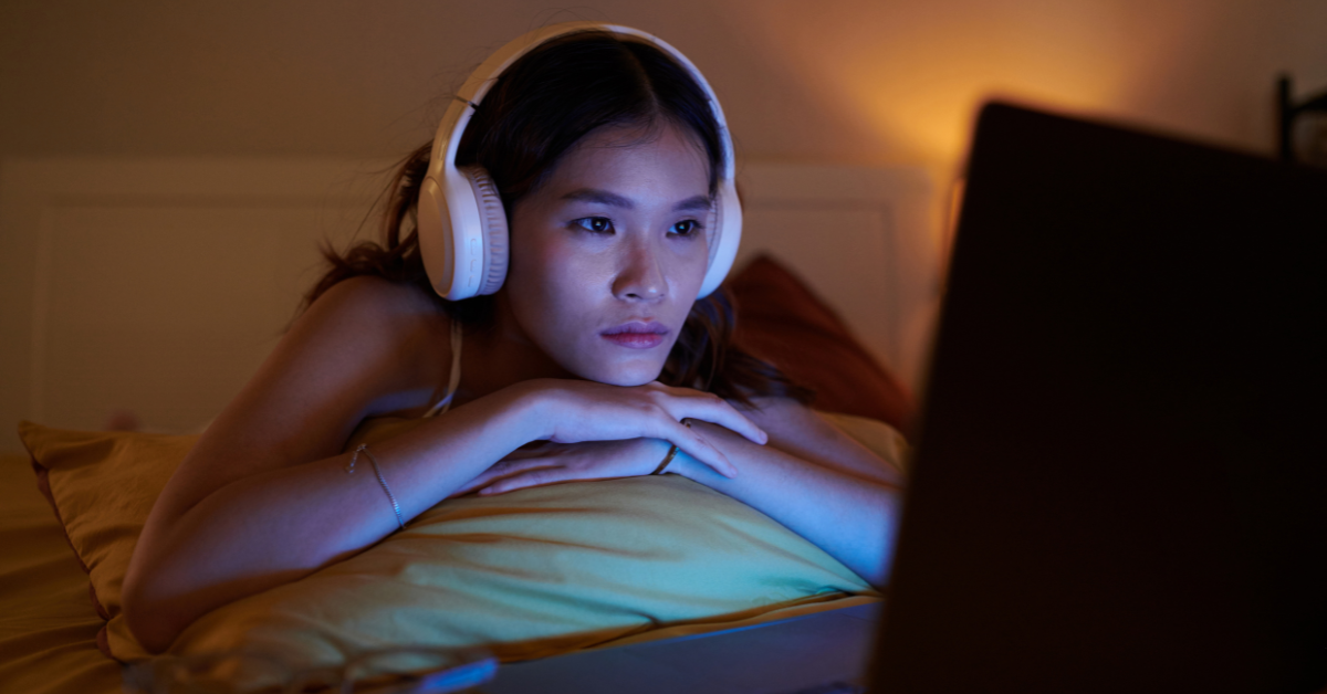 A woman watching a video tutorial about how to choose the principal business code OnlyFans requires for taxes.
