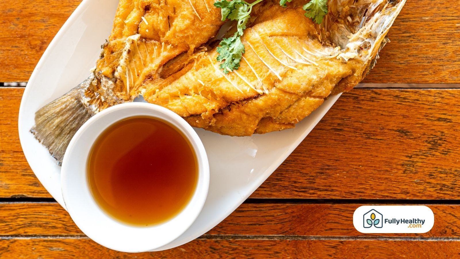 Fried fish served with dipping sauce in bowl