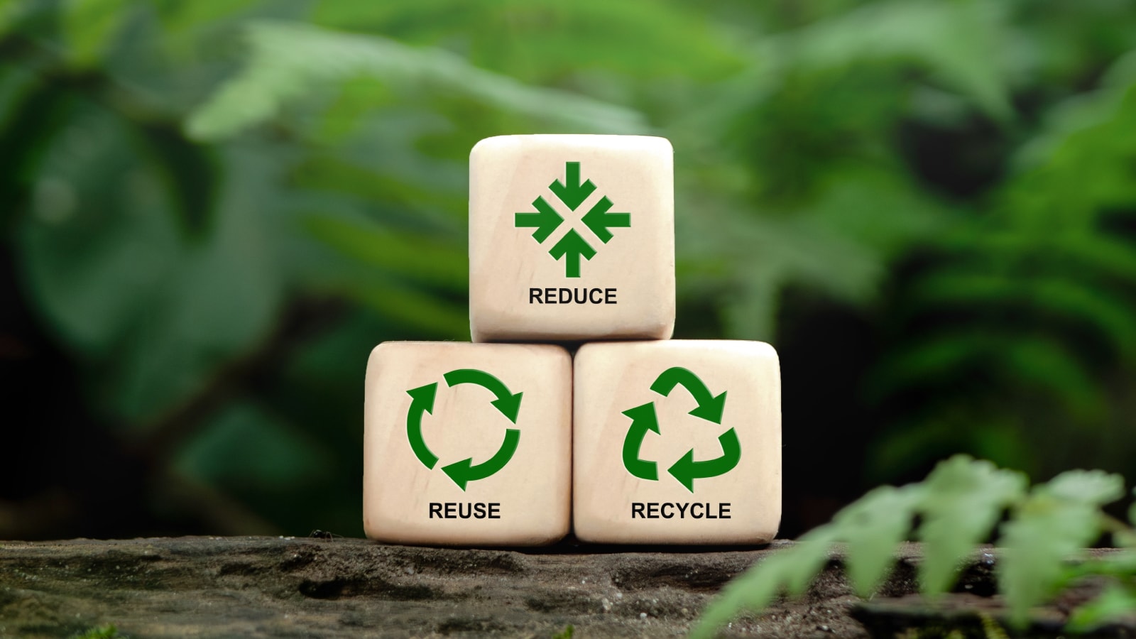 Ilustrasi prinsip 3R: Reduce, Reuse, Recycle pada kubus kayu dengan latar belakang hijau alami