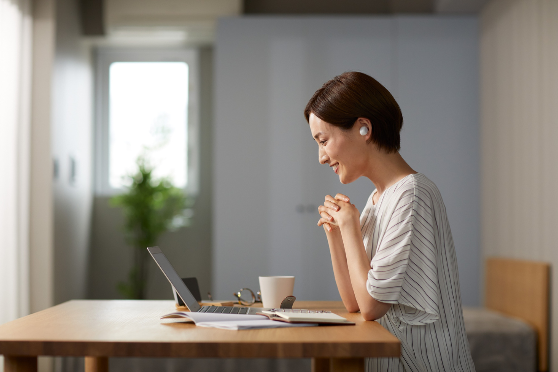 Woman attending a virtual supplement facility tour from a home office