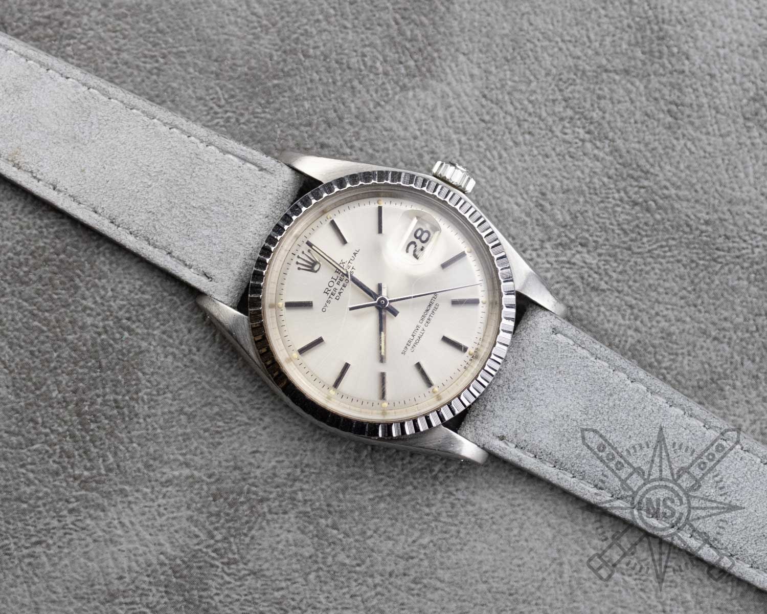 A gray suede watch strap elegantly displayed on a wrist.