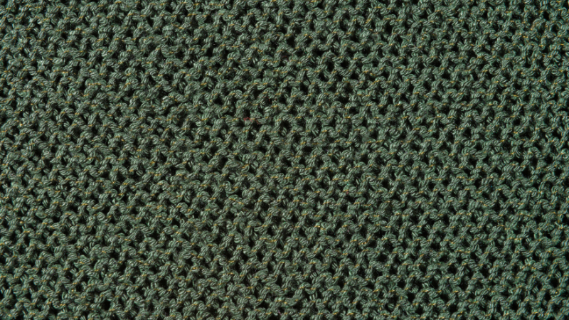 A close up view of a green knitted textured fabric