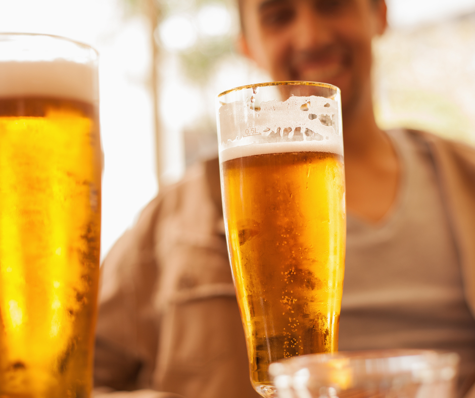                                         A person looking at a glass of beer and thinking about drinking it