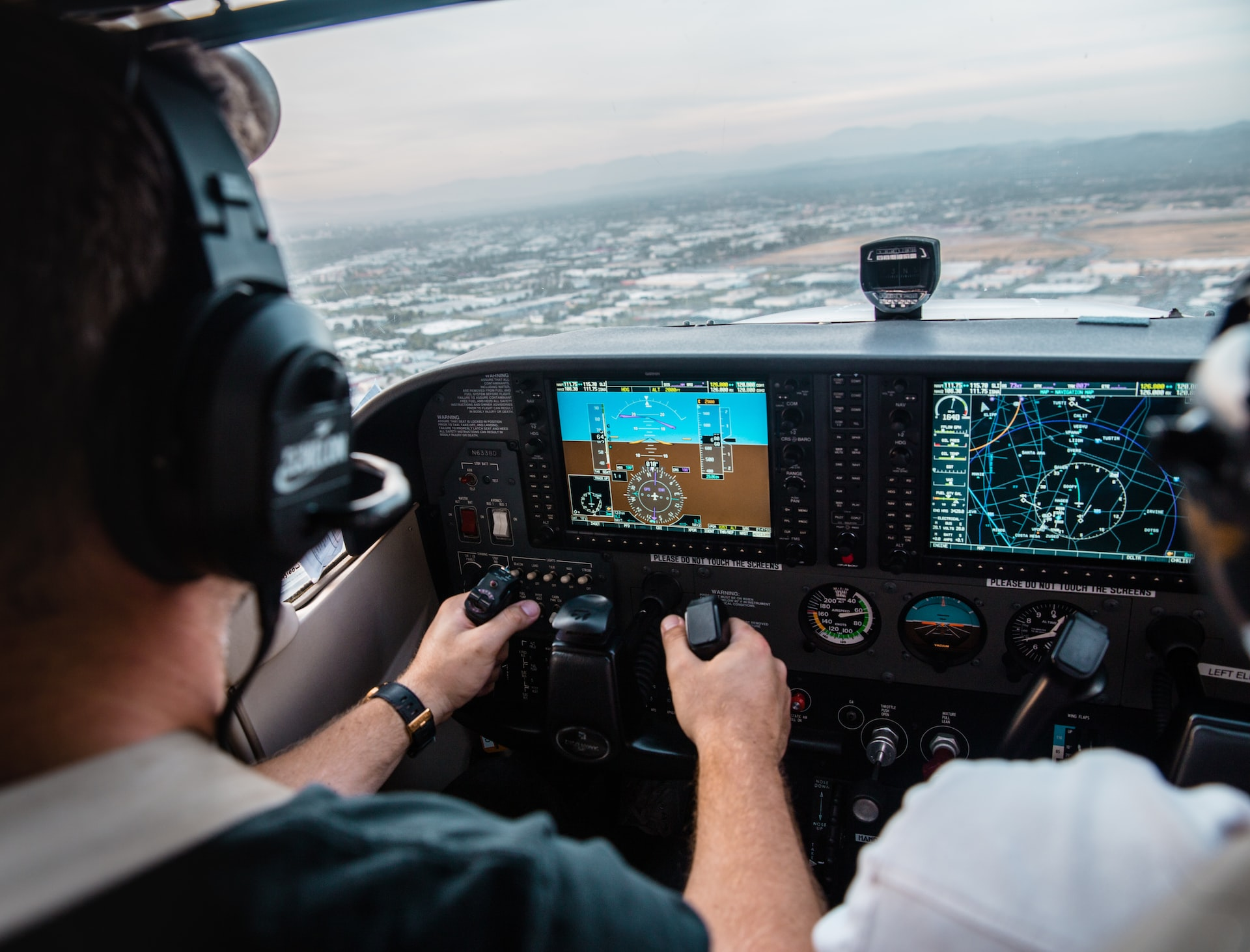 Two pilots in a cockpit navigating an aircraft and maintaining a green V speed.