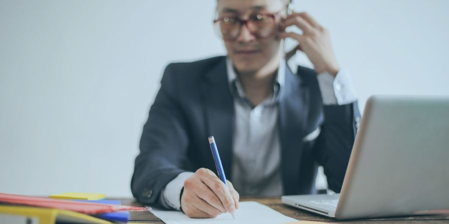 Man holding a pen and making phone calls in his office