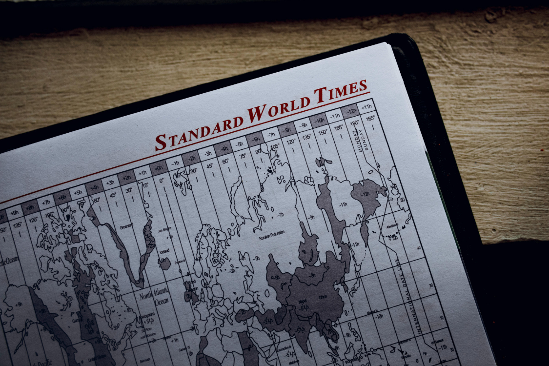 A printed world time zone map showing global time differences relevant to offshore team scheduling