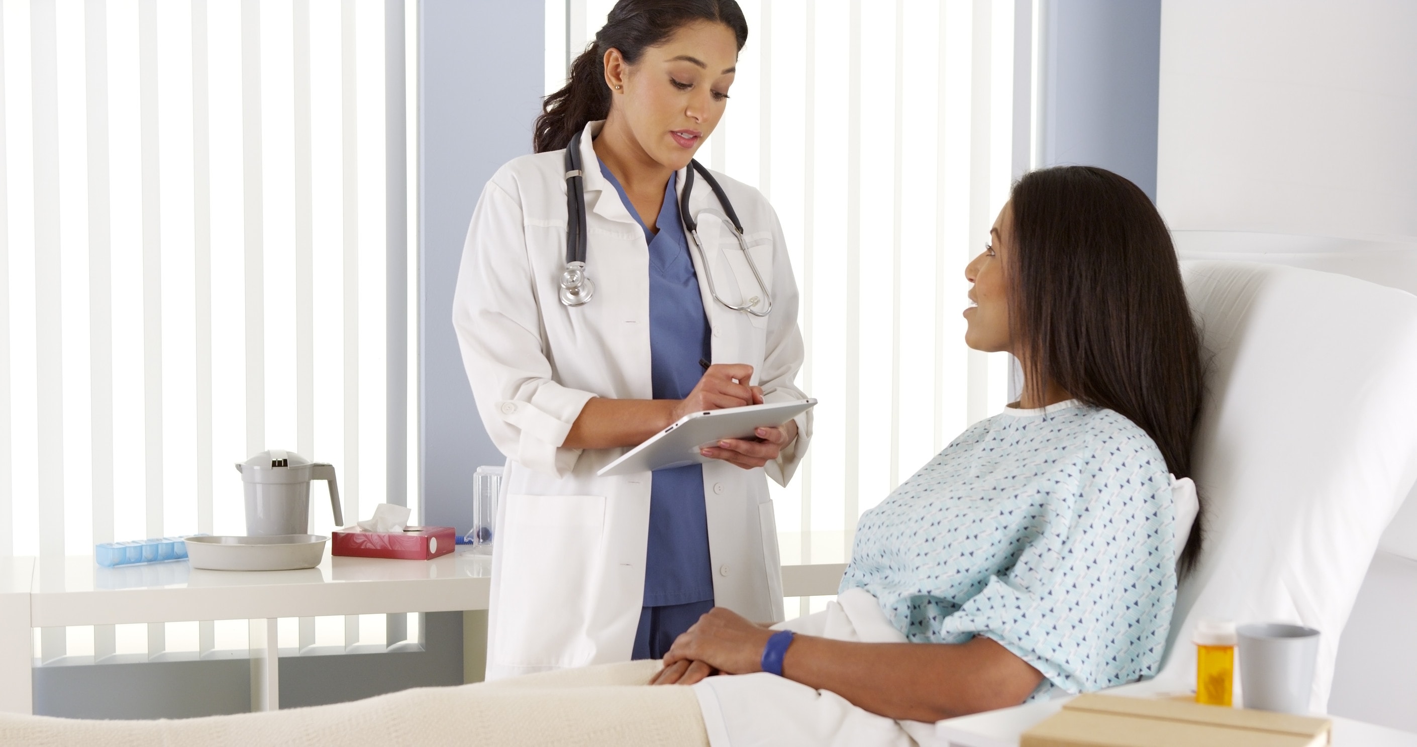 A woman in a hospital bed receives negligent treatment from a doctor 