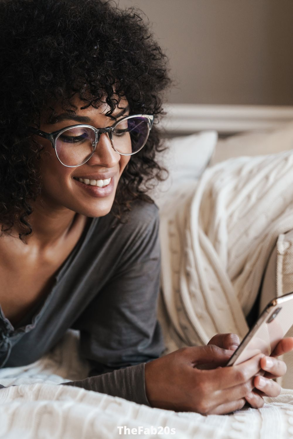 Woman smiling at phone - Featured in Signs A Married Man Likes You But Is Hiding It