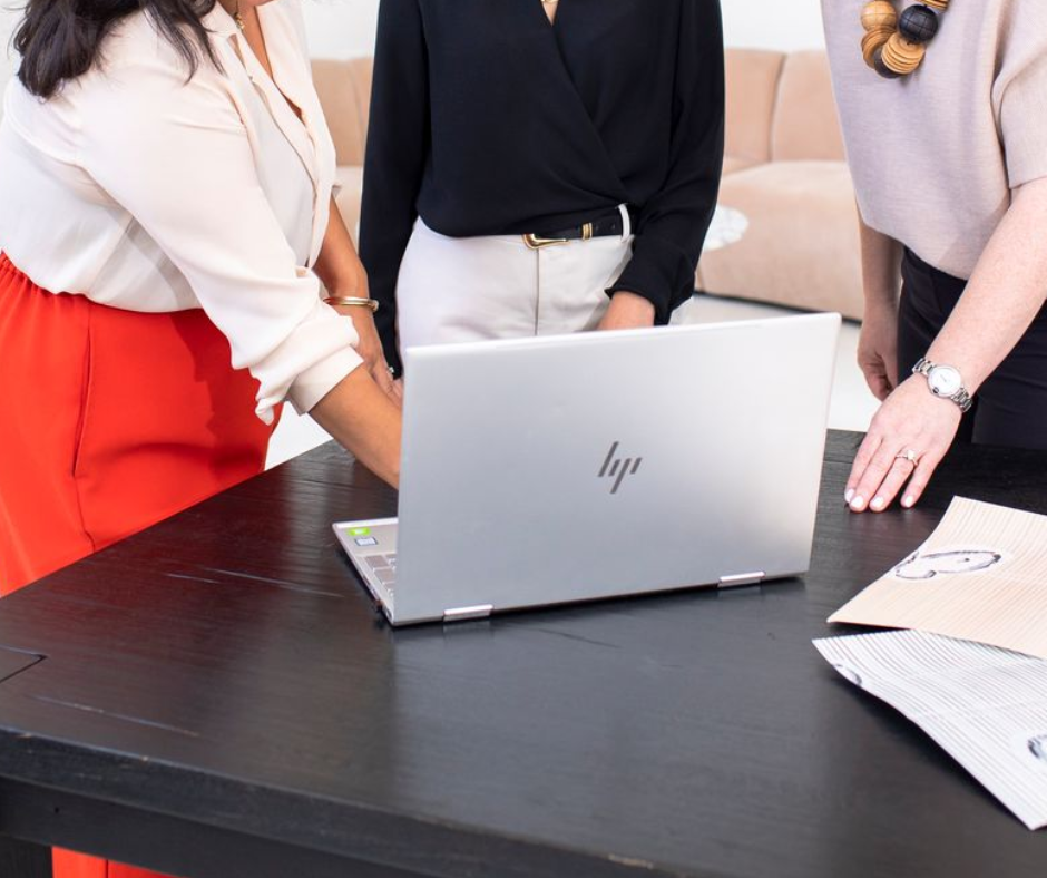 three designers gather around an HP laptop