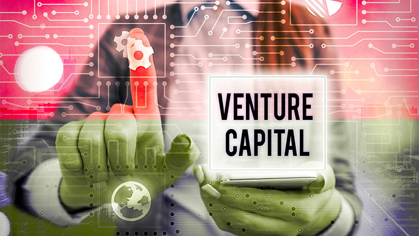 An image with a man pressing a button on a motherboard and venture capital sign. 