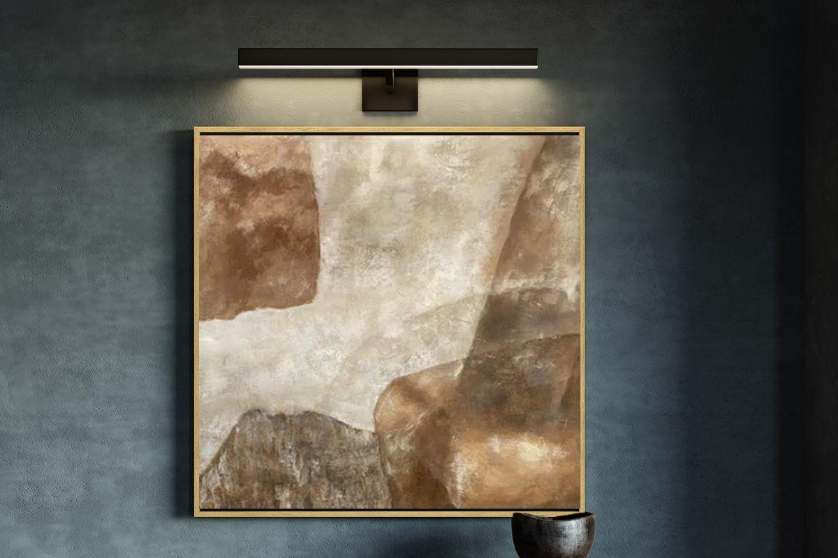 Picture light wall fixture ideas with modern wall mounted light highlighting artwork in a dark, elegant space