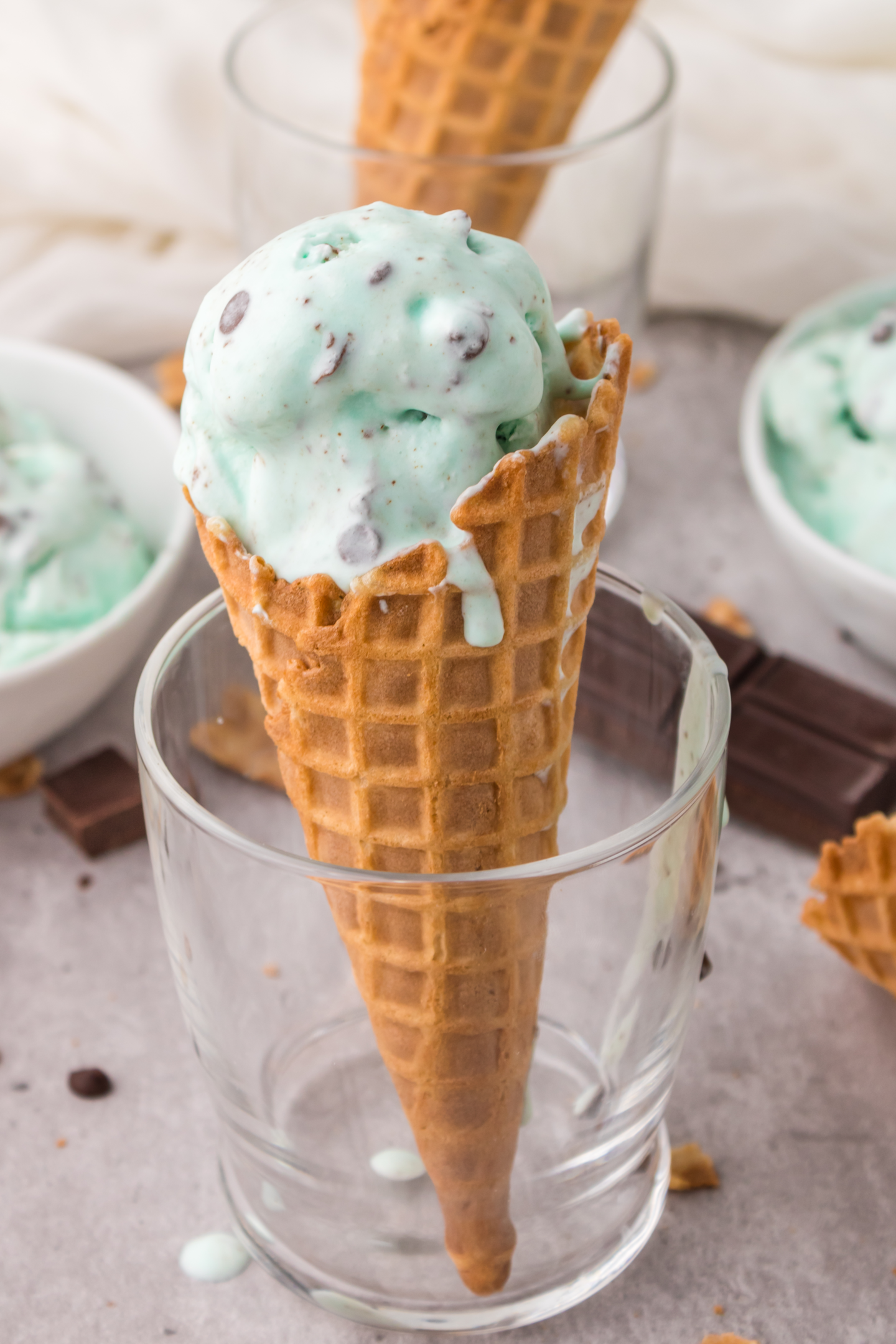 mint chocolate chip ice cream in a cone in a glass