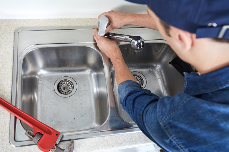 Handwerker arbeitet an einer Küchenspüle.
