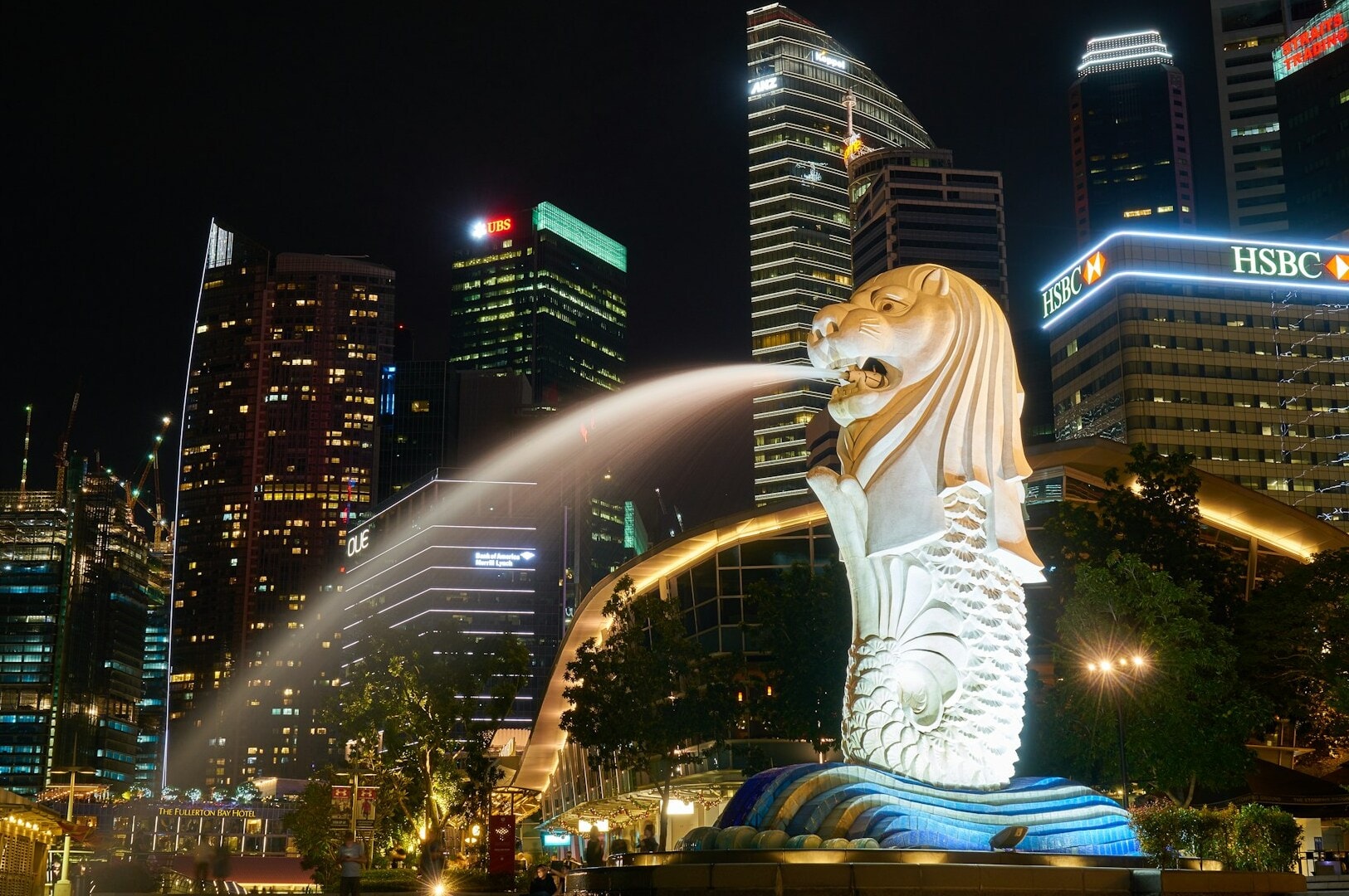 The Merlion statue sprays water, with Singapore's city skyline in the background, highlighting the city's vibrant atmosphere.