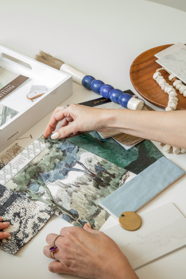 an interior designer arranging samples, creating a serene space by incorporating elements that work well for understated elegance