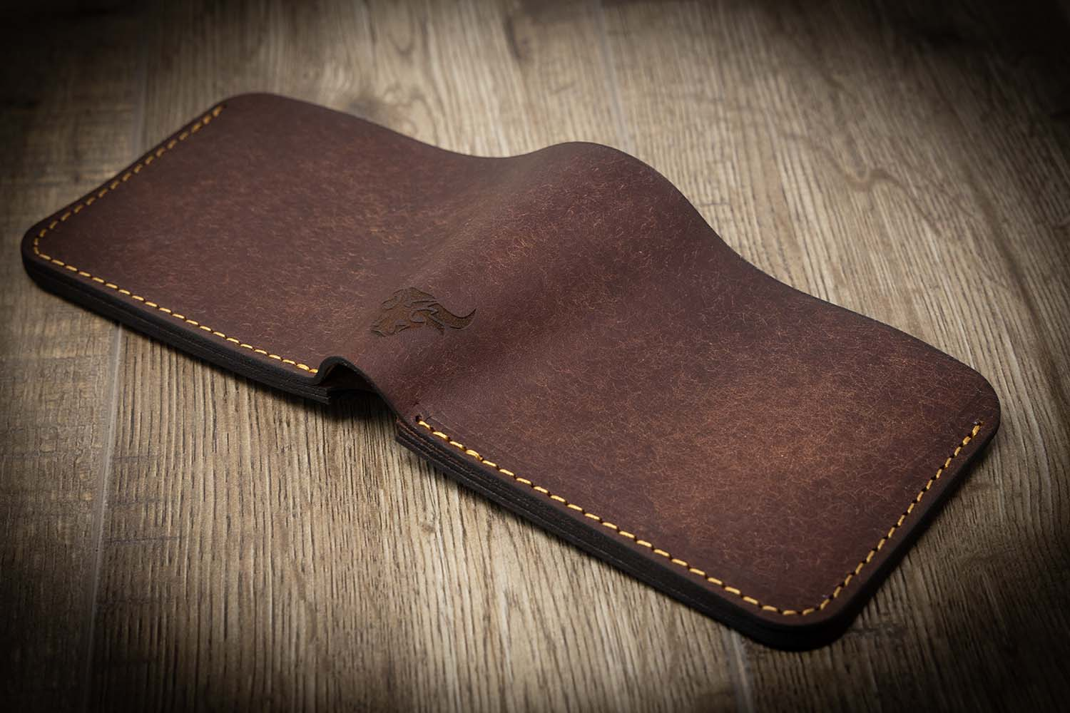 A leather bifold wallet with vegetable tanned leather and a pocket for cash.