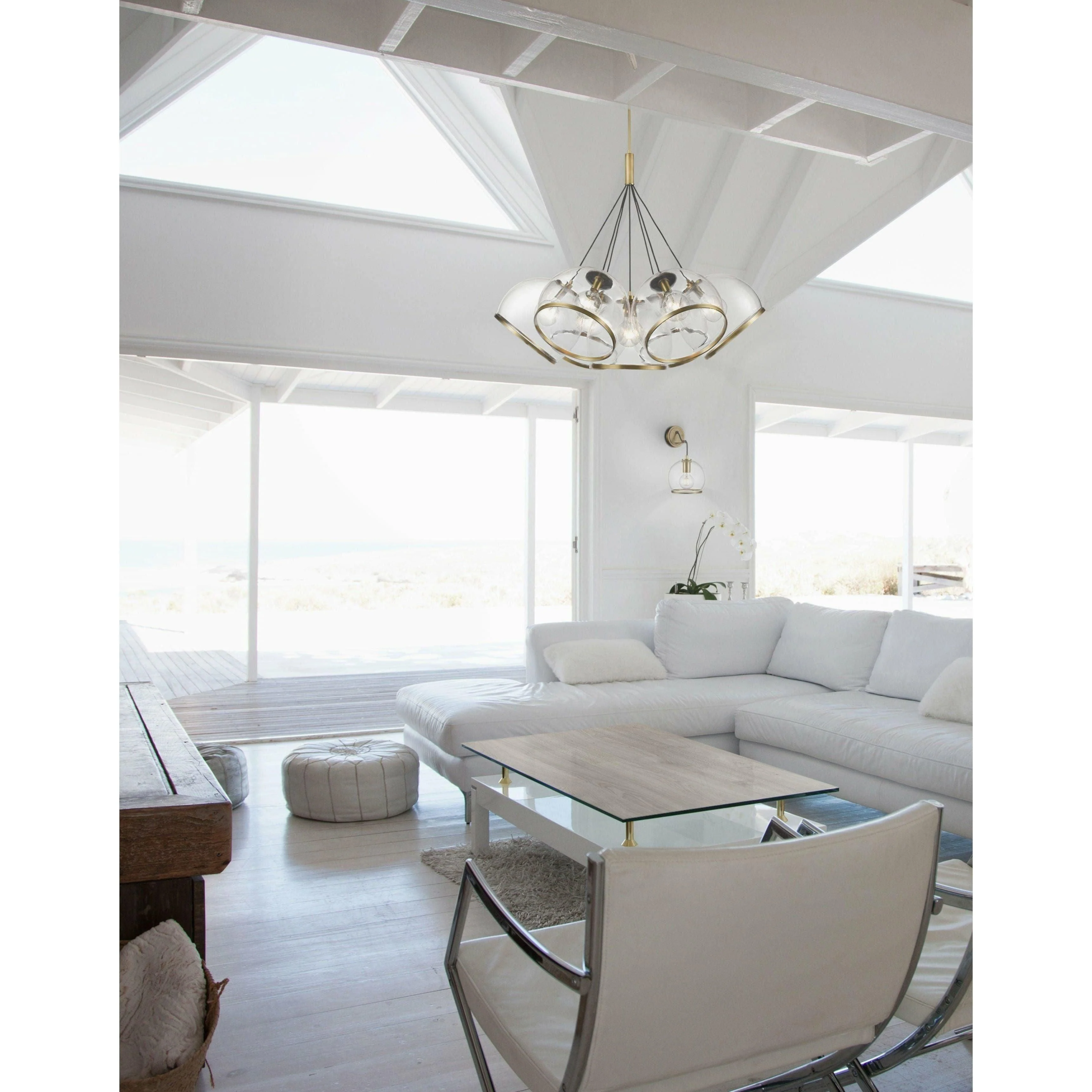 Bright, airy living room with the Coast Pendant light fixture, featuring modern glass and brass elements, hanging over a white sectional sofa, creating a relaxed coastal aesthetic.