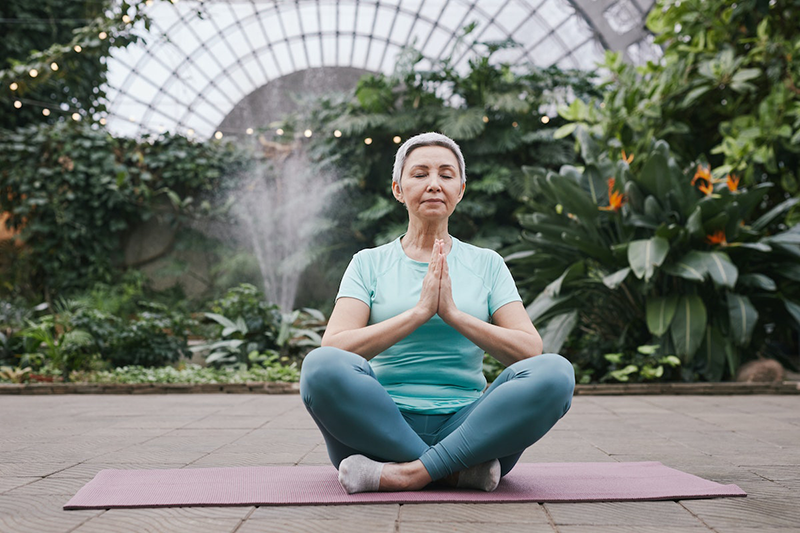 Practicing mindfulness: Woman on a yoga mat practicing mindfulness meditation