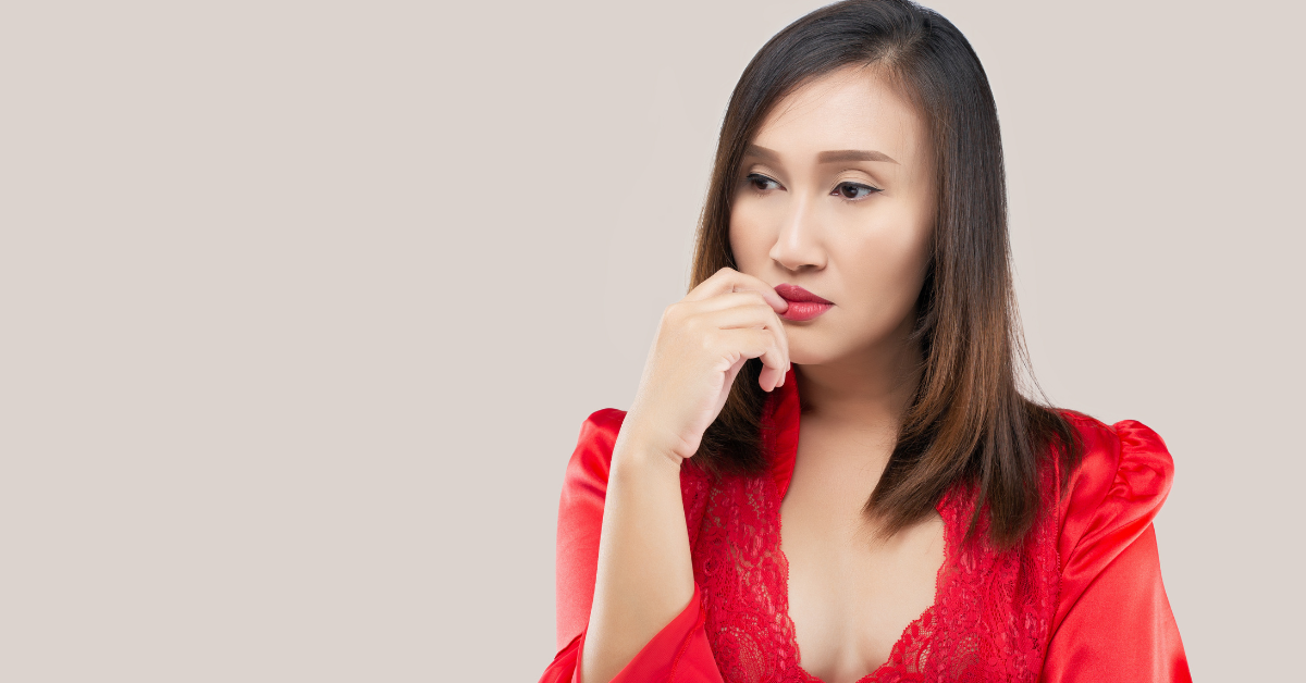 Woman in red lingerie reflects on what is QBI deduction and how it affects OnlyFans business taxes.