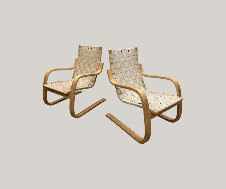 Two matching armchairs with woven webbing seats and backs, supported by light birch bent-wood cantilevered frames.