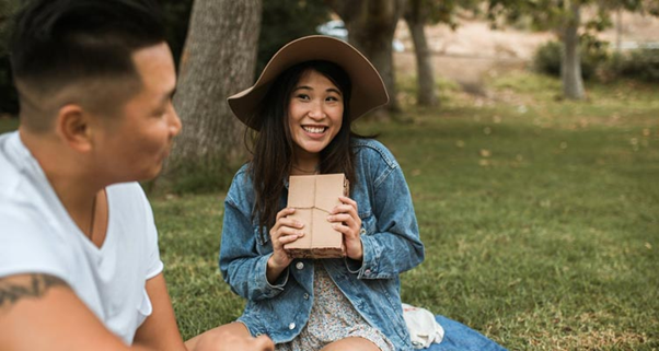 A girl offering a guy she likes a gift package while on a picnic https://www.bonobology.com/girl-likes-hiding/