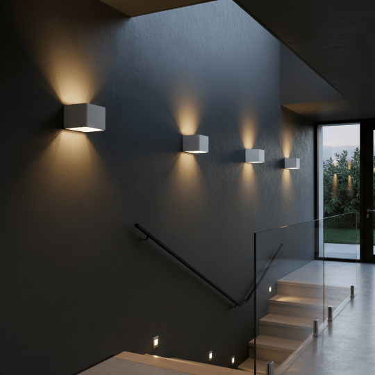 Row of modern cube wall sconces casting up-and-down light along a dark stairwell with glass railing.