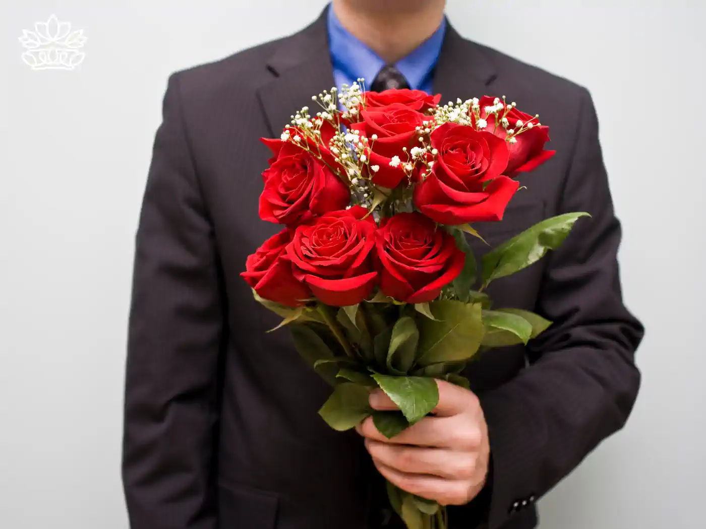 Gentleman in a suit holding a bouquet of vibrant red roses with baby's breath, embodying sophistication and affection with flower bouquets under R500, thoughtfully delivered by Fabulous Flowers and Gifts.