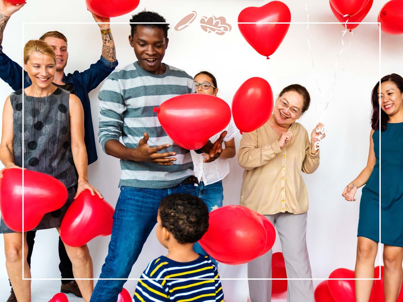 Friends laughing as heart balloons float and bounce; playful Valentine’s party moment on a white studio background.