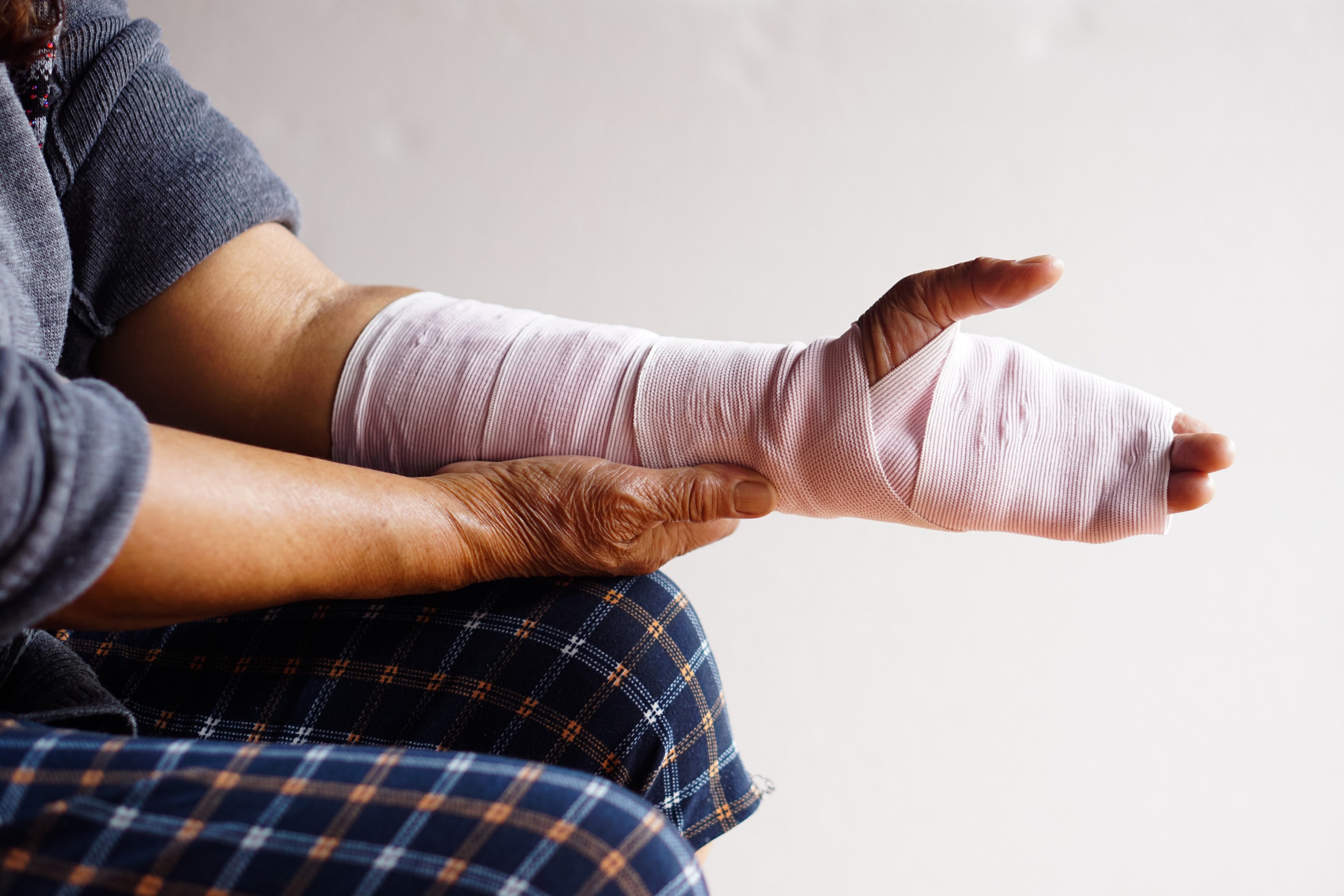 A man with a bandaged finger and striped pyjama pants makes a hand injury compensation claim