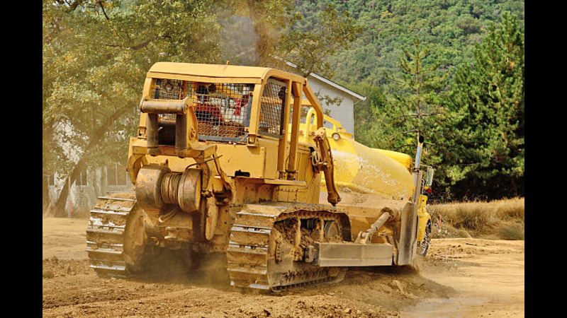 A skid steer leveling road. 