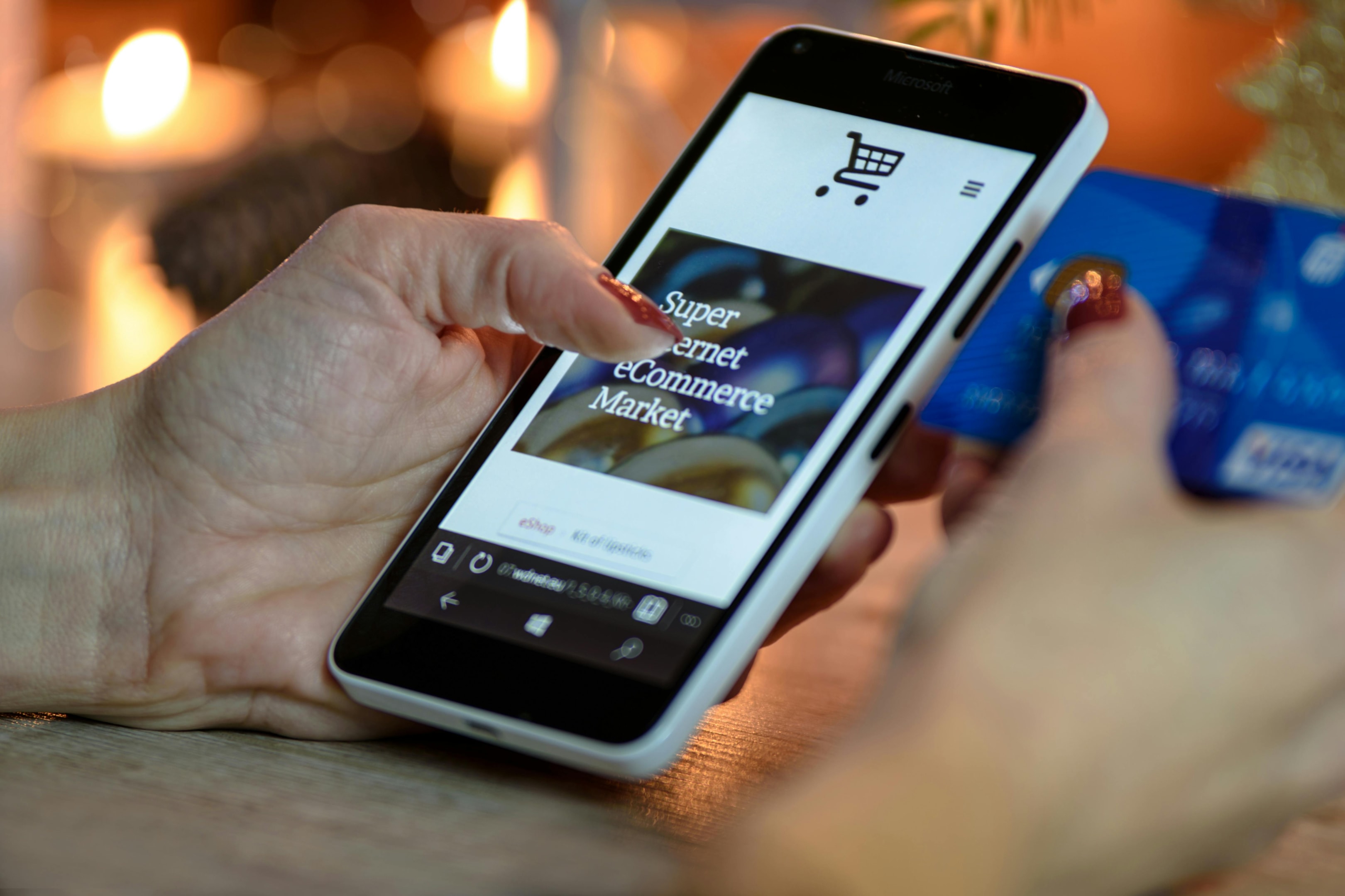 Hands with manicured nails holding mobile phone and credit card