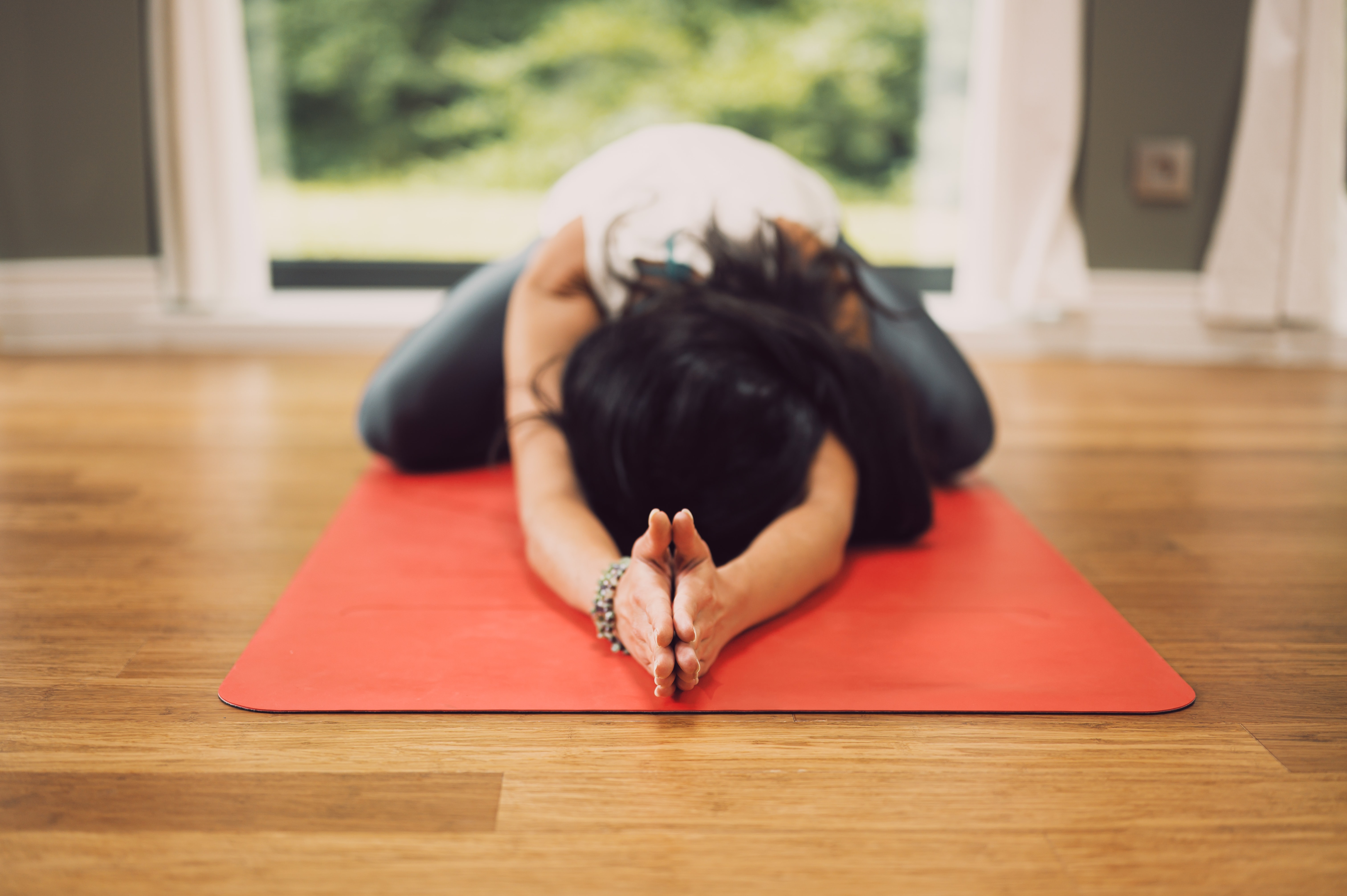 woman practicing yoga on orange mat self sustaining