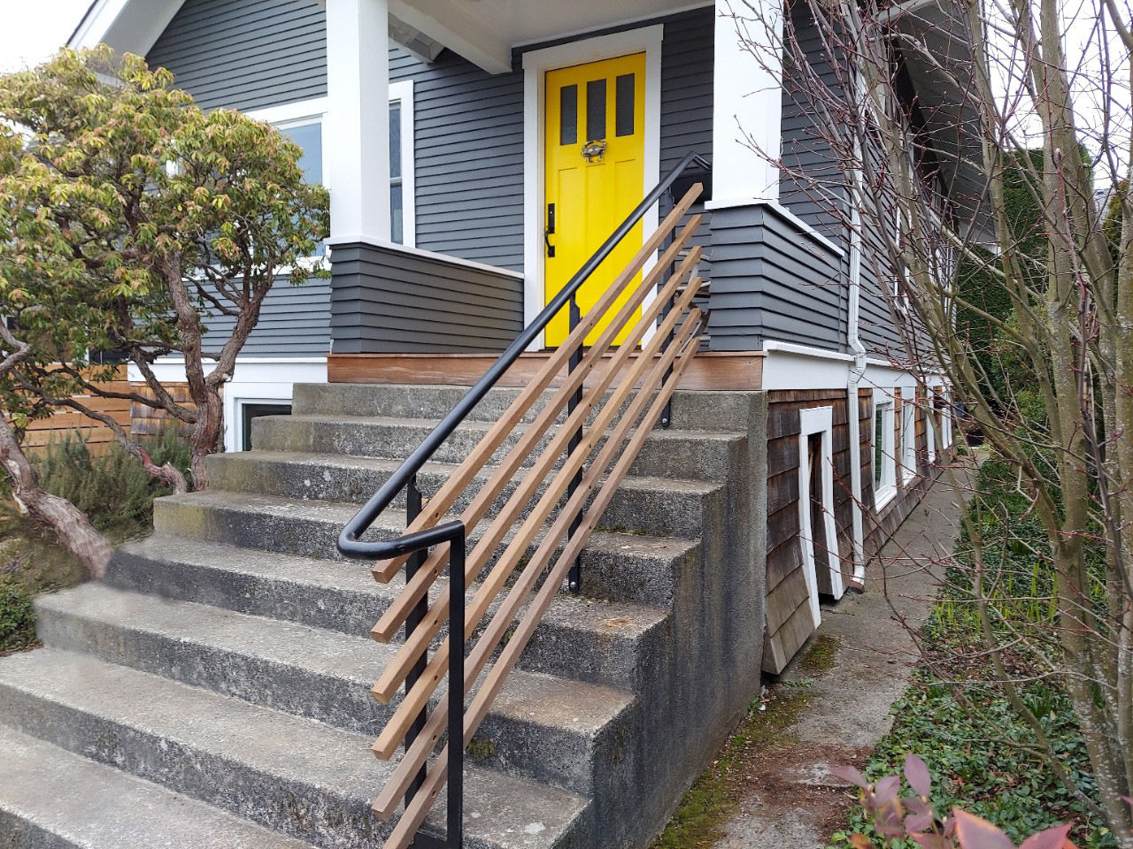 Bright yellow front door with updated porch railings.