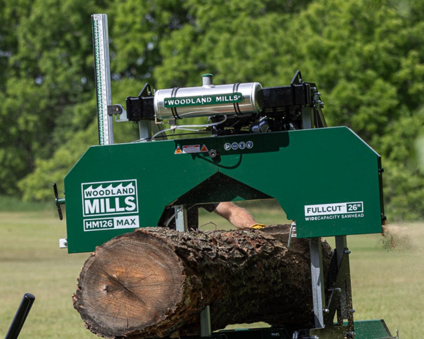 The Woodland Mills HM126MAX Portable Sawmill cutting into a log.