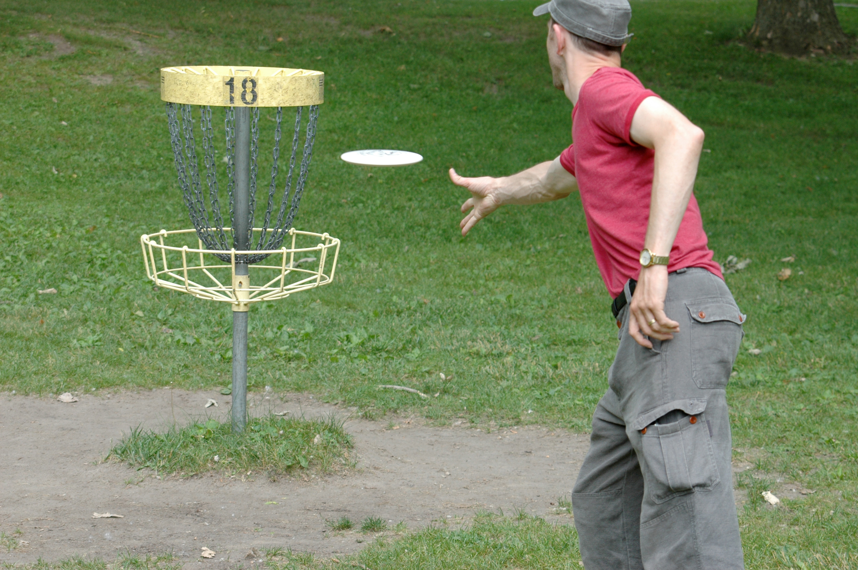 Man tossing a golf disc at a park