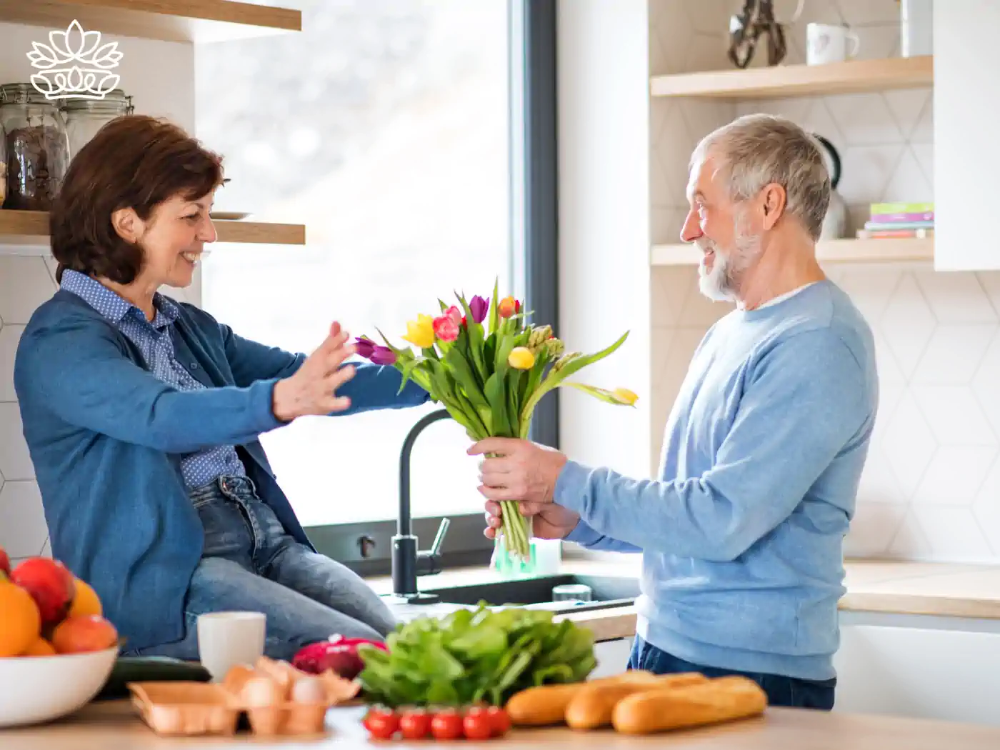 Senior man surprising his wife with a bouquet of colourful tulips in a bright kitchen, capturing the essence of affordable elegance with flower bouquets under R500, lovingly delivered by Fabulous Flowers and Gifts