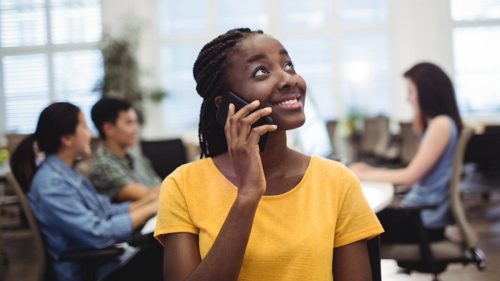 Smiling employee using a business voice solution from Ten4 that enables seamless communication among multiple users.