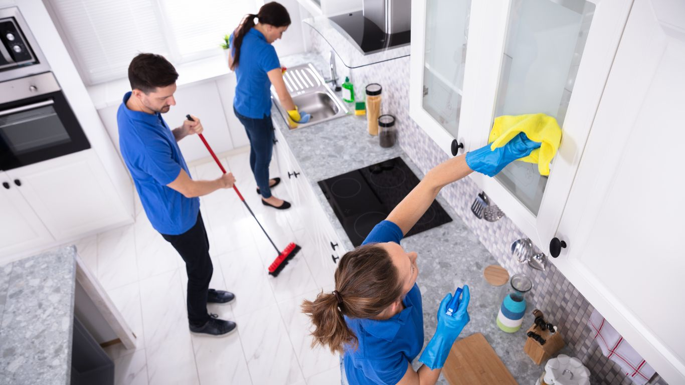 A team of professional cleaners cleaning a kitchen