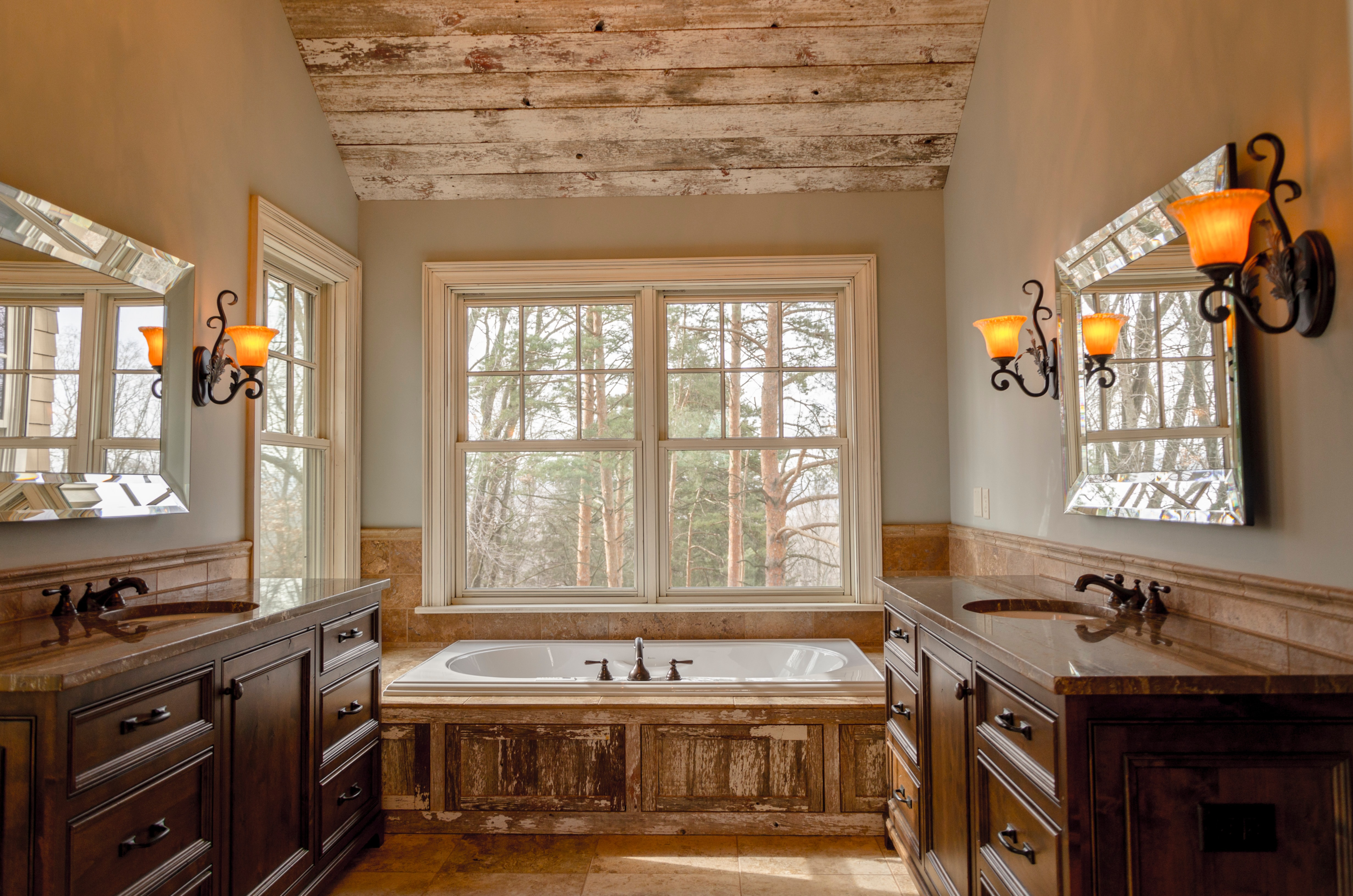 A beautiful rustic bathroom with an abundance of exposed wood and ornate lighting fixtures