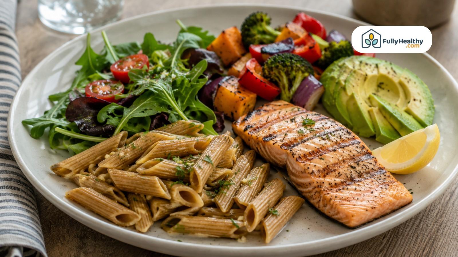 Grilled salmon plate with whole-grain pasta, greens, roasted vegetables, avocado, and lemon