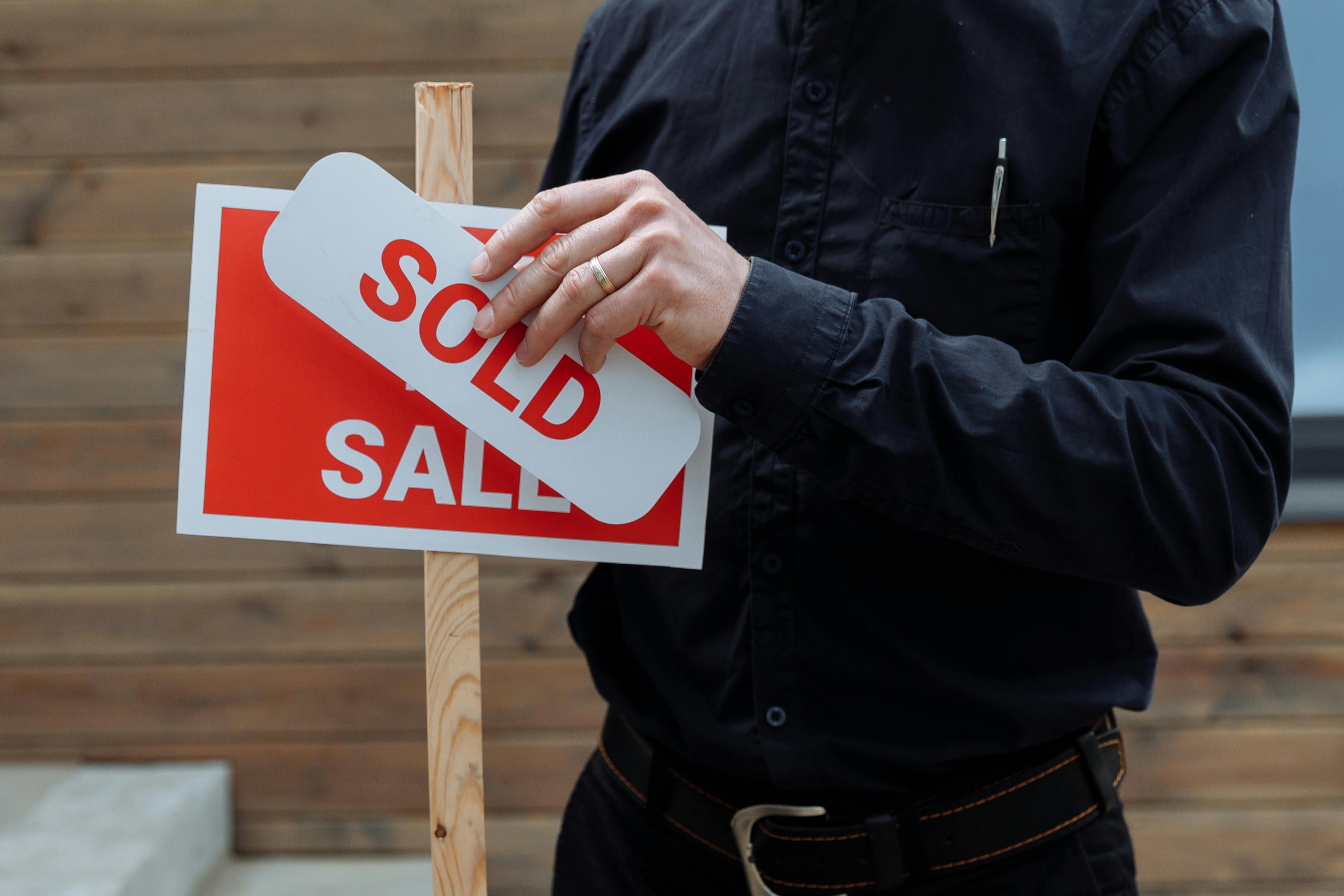 Sold sign being put up in front of investment property. 