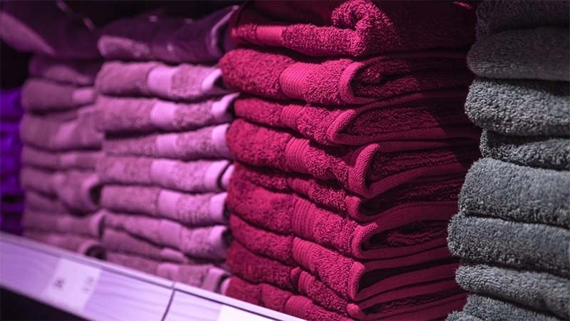 A shelf full of different cleaning towels