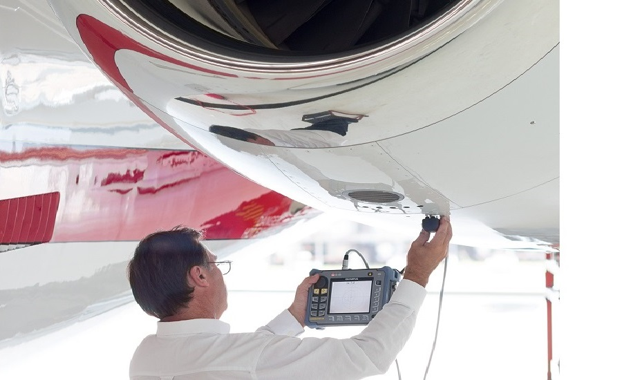 NDT technician inspecting an aircraft component with acoustic emission testing