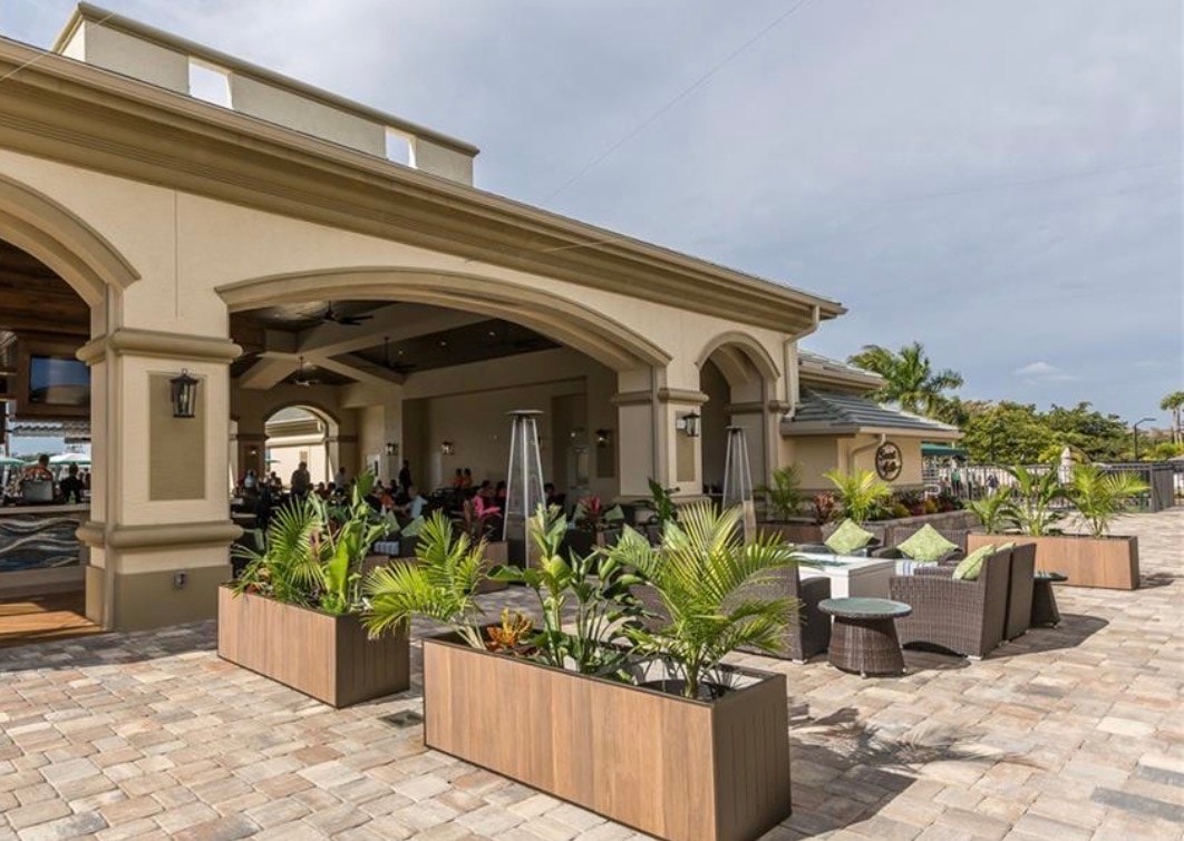 The image depicts a professional golf course featuring lush fairways, strategically placed sand bunkers, and water hazards, all set against the beautiful Florida landscape. This picturesque setting at the Legends Golf and Country Club offers a legendary experience for golfers, with manicured greens and stunning views that enhance the golfing experience.