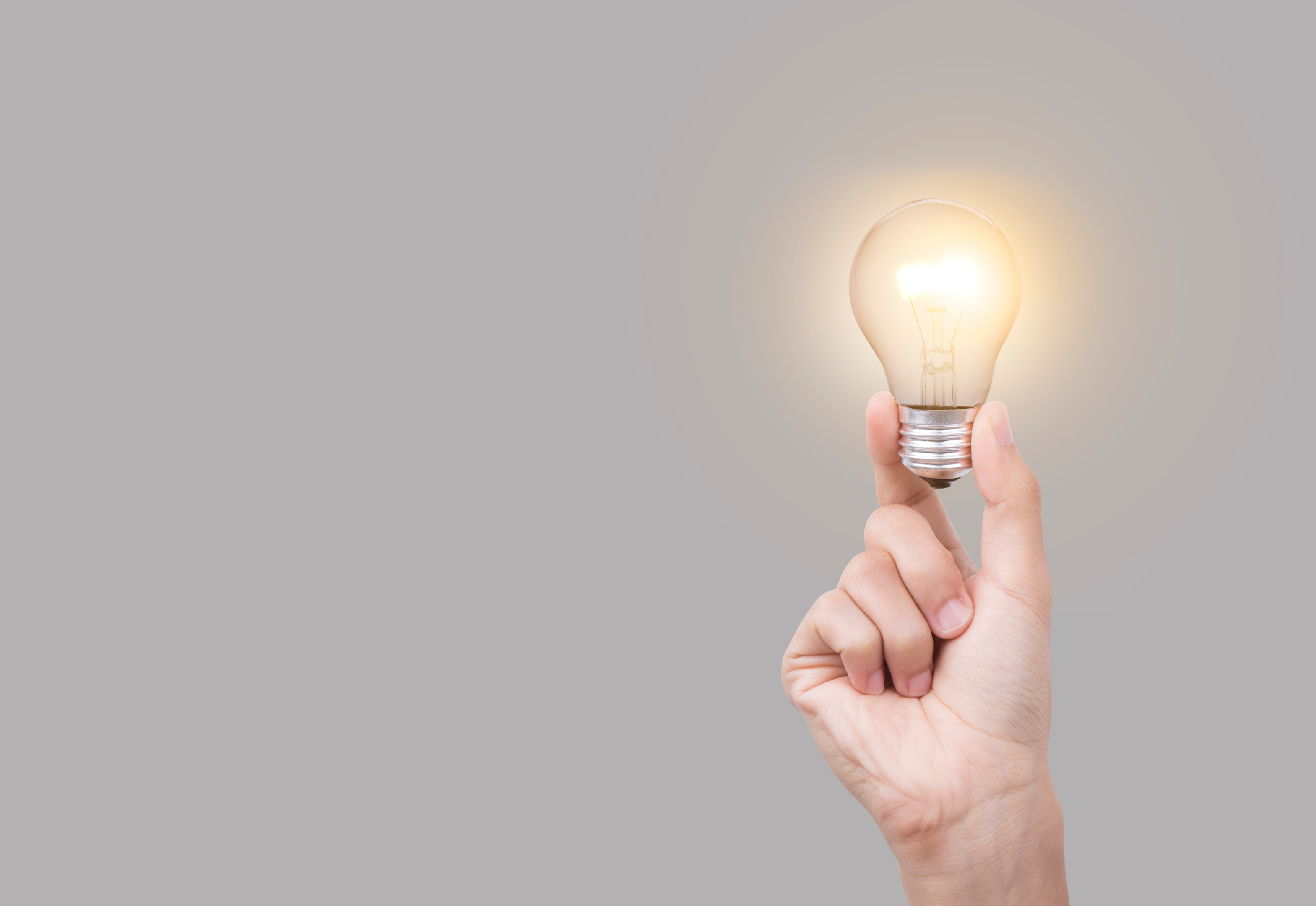 An image depicting a person holding a lightbulb, representing the idea of what is an entrepreneur and identifying opportunities.